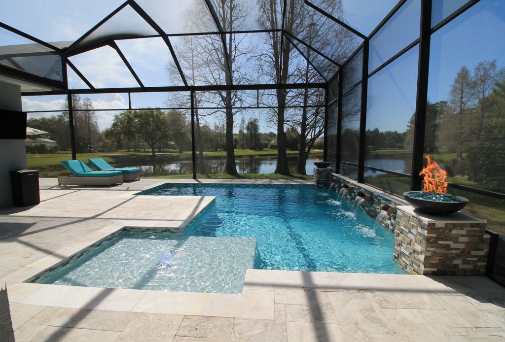 A large screened in swimming pool with a fire pit