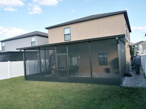 There is a screened in porch in the backyard of a house.