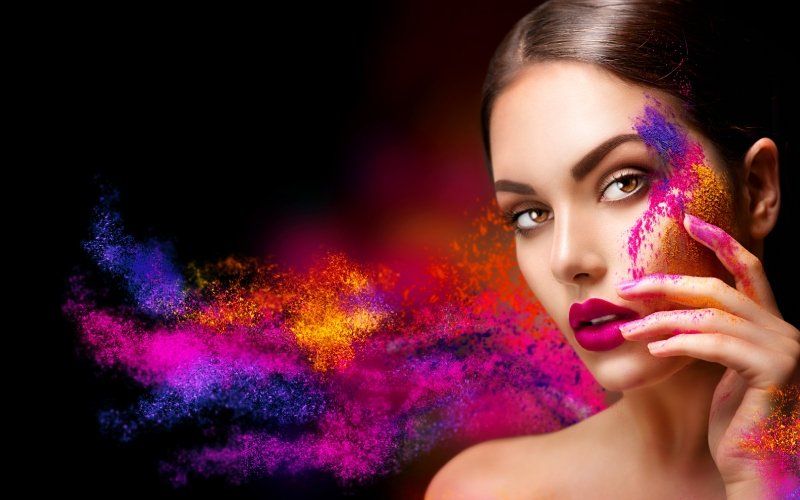 Modella con make-up e sfumature di colore sullo sfondo