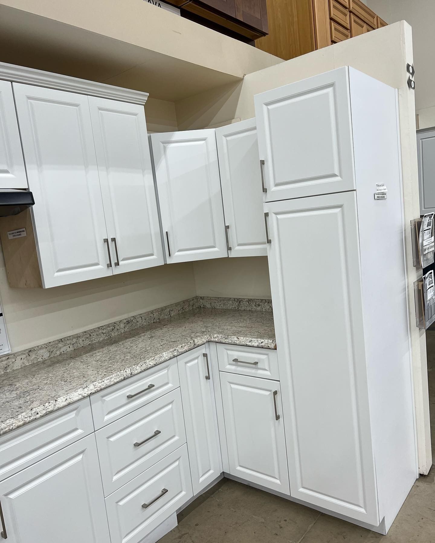 A kitchen with white cabinets and granite counter tops