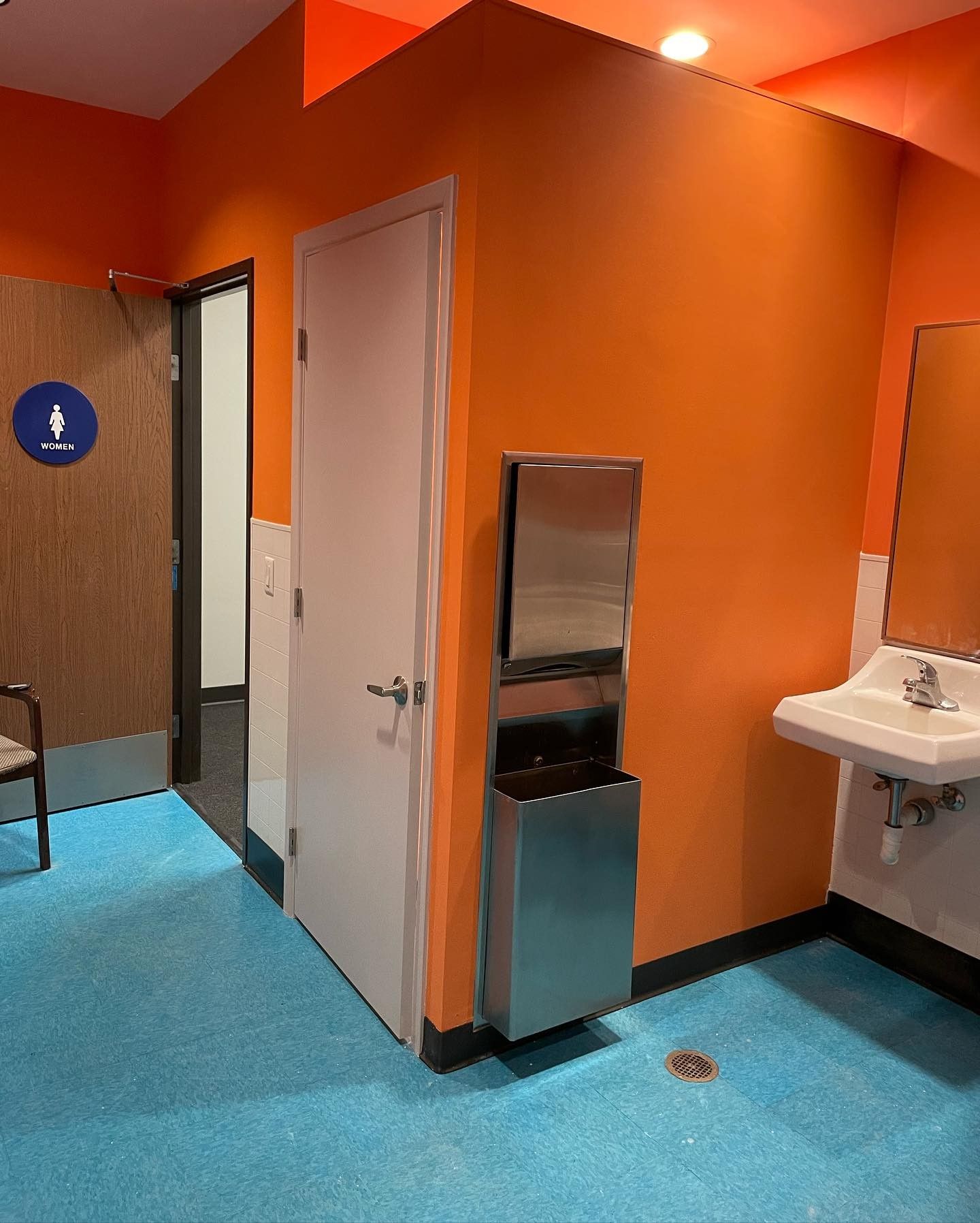 A bathroom with orange walls and a sink.