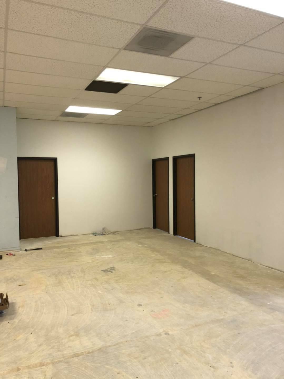 An empty room with two doors and a ceiling light.