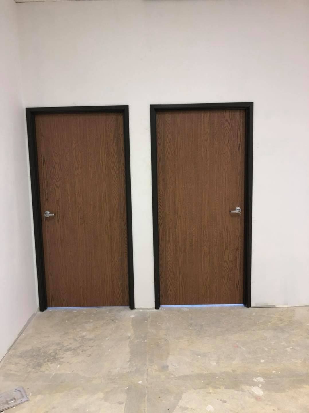 Two wooden doors are sitting next to each other in a room.