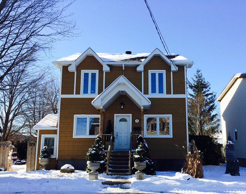Une maison avec de la neige sur le sol devant elle