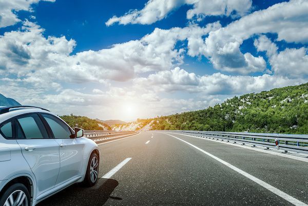 A white car is parked on the side of a highway. | Lex Brodies 