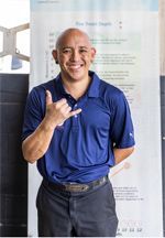 A man in a blue shirt is smiling and giving a thumbs up. | Lex Brodies 