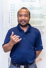 A man in a blue shirt is standing in front of a white board. | Lex Brodies 