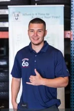A young man in a blue polo shirt is giving a thumbs up. | Lex Brodies 