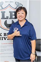 A woman in a blue shirt is giving a thumbs up. | Lex Brodies 