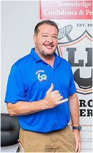 A man in a blue shirt is giving a thumbs up. | Lex Brodies 