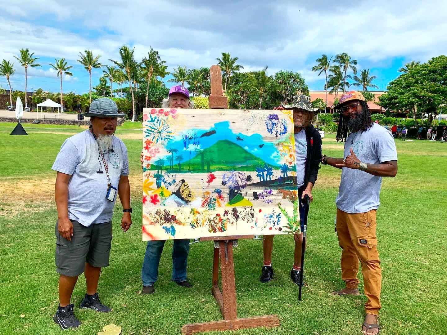 A group of men are standing around a painting on an easel in a park.