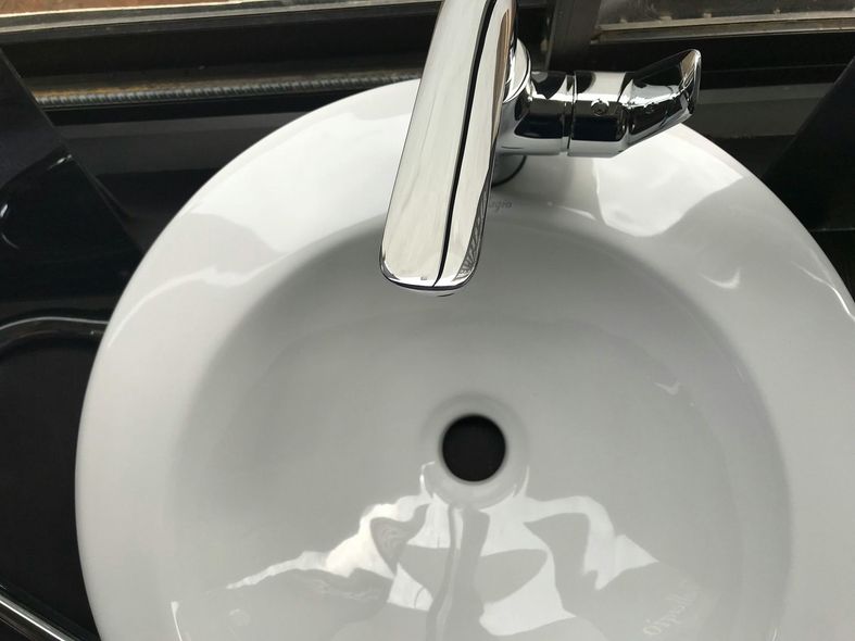 White, round bathroom sink with a chrome faucet.