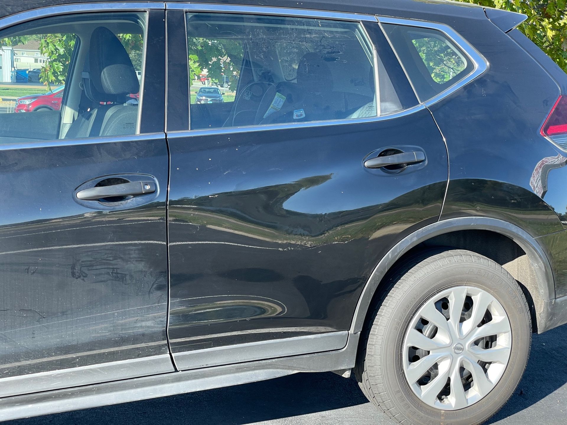Black SUV parked outdoors, side view with visible rear wheel and windows