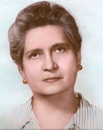 Woman with short gray hair, wearing gold earrings and a striped shirt, looking upwards.