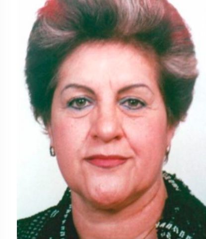 Woman with short, styled hair, wearing earrings, looking at the camera.