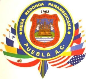 Logo of Mesa Redonda Panamericana Puebla A.C. from 1963, featuring a central shield surrounded by flags.