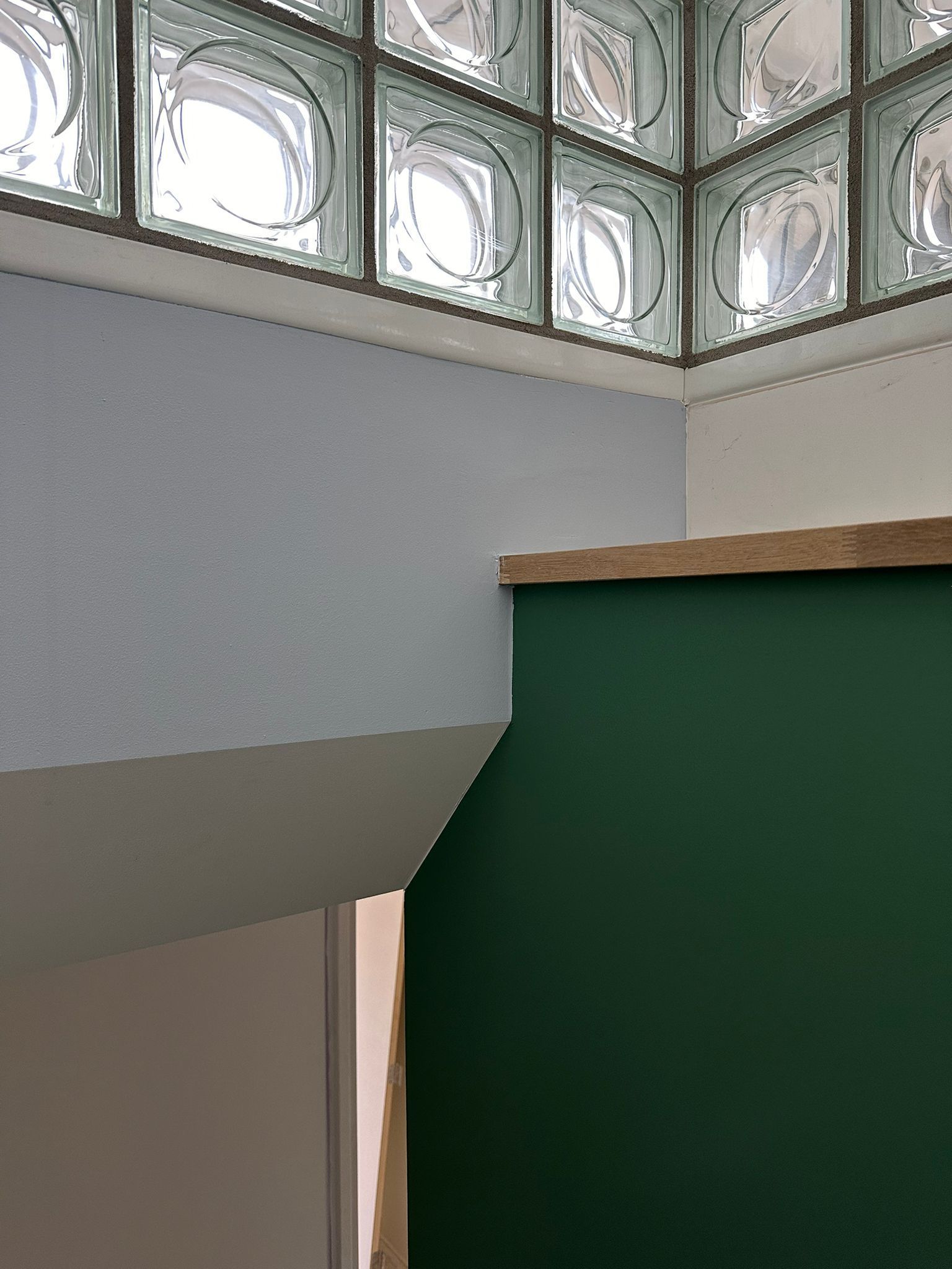 interieur met groene, witte en grijze muren, een raam van glazen bouwstenen en een lamp. Glazen blokken. Glass blocks