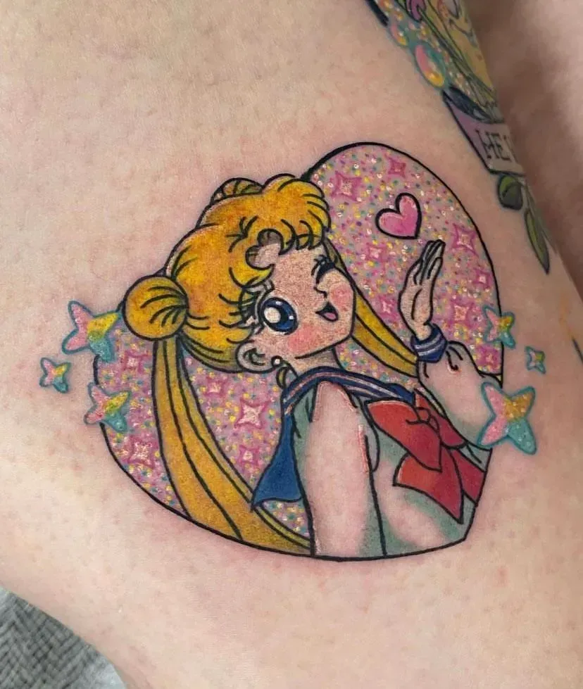 Sailor Moon tattoo in a pink glitter heart, waving with stars.