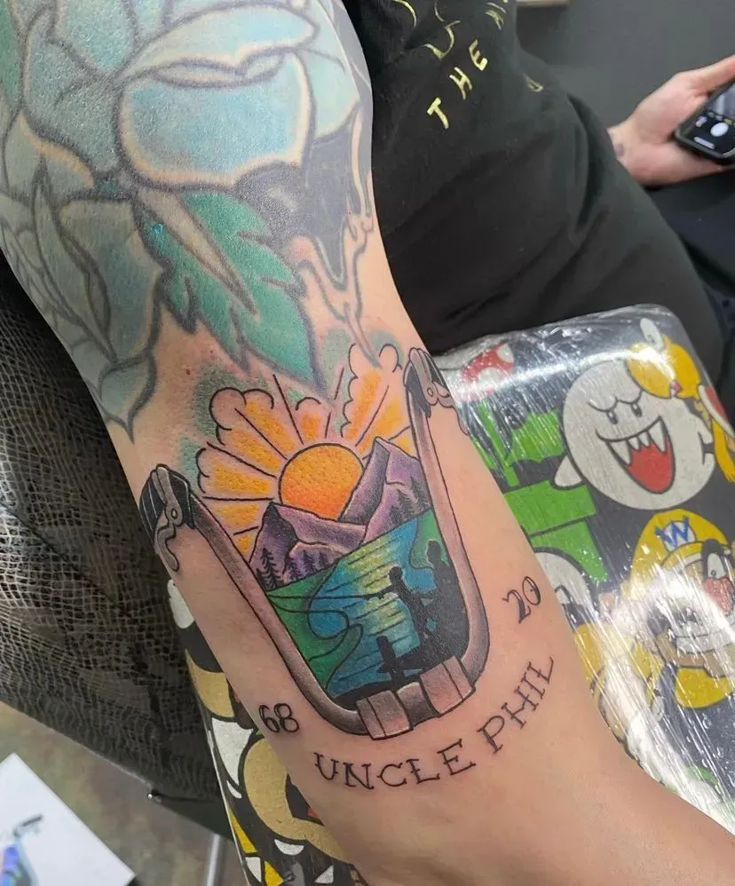 Tattoo of a sunrise over mountains, with