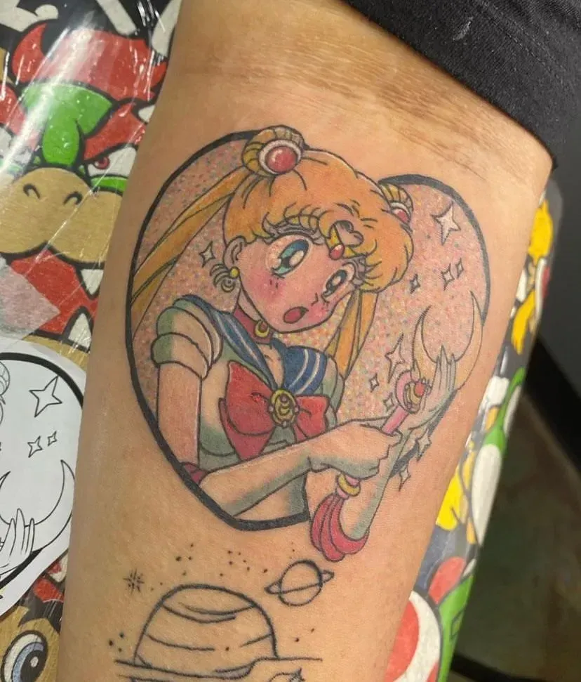 Sailor Moon tattoo, framed by a heart, holding a scepter, surrounded by stars.