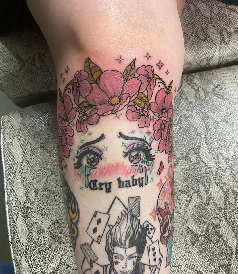Tattoo of crying eyes, floral crown, and text