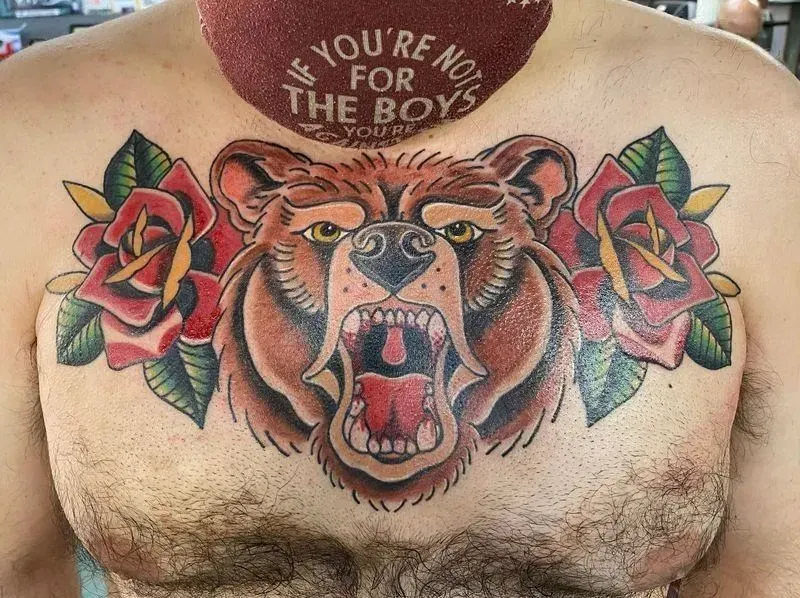 Chest tattoo: roaring brown bear with red roses and green leaves.