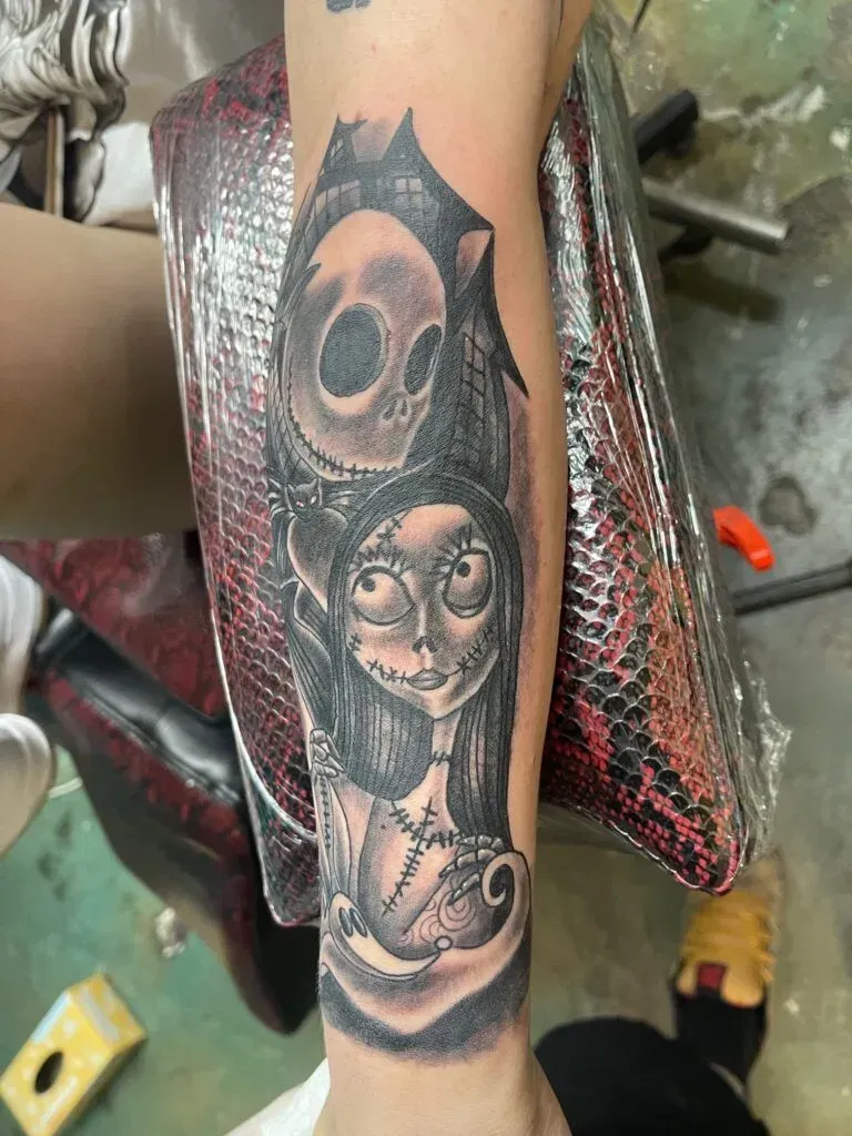 Black and grey tattoo of Jack Skellington and Sally from