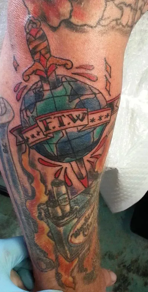 Tattoo on arm, globe pierced by dagger,