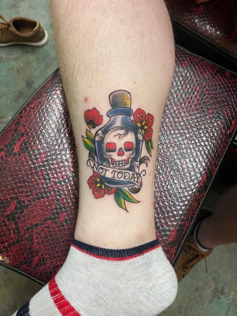 Tattoo on a leg. A skull inside a bottle with