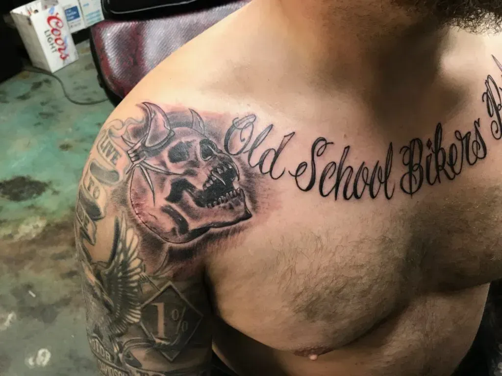 Man's shoulder and chest tattoo: skull with horns,