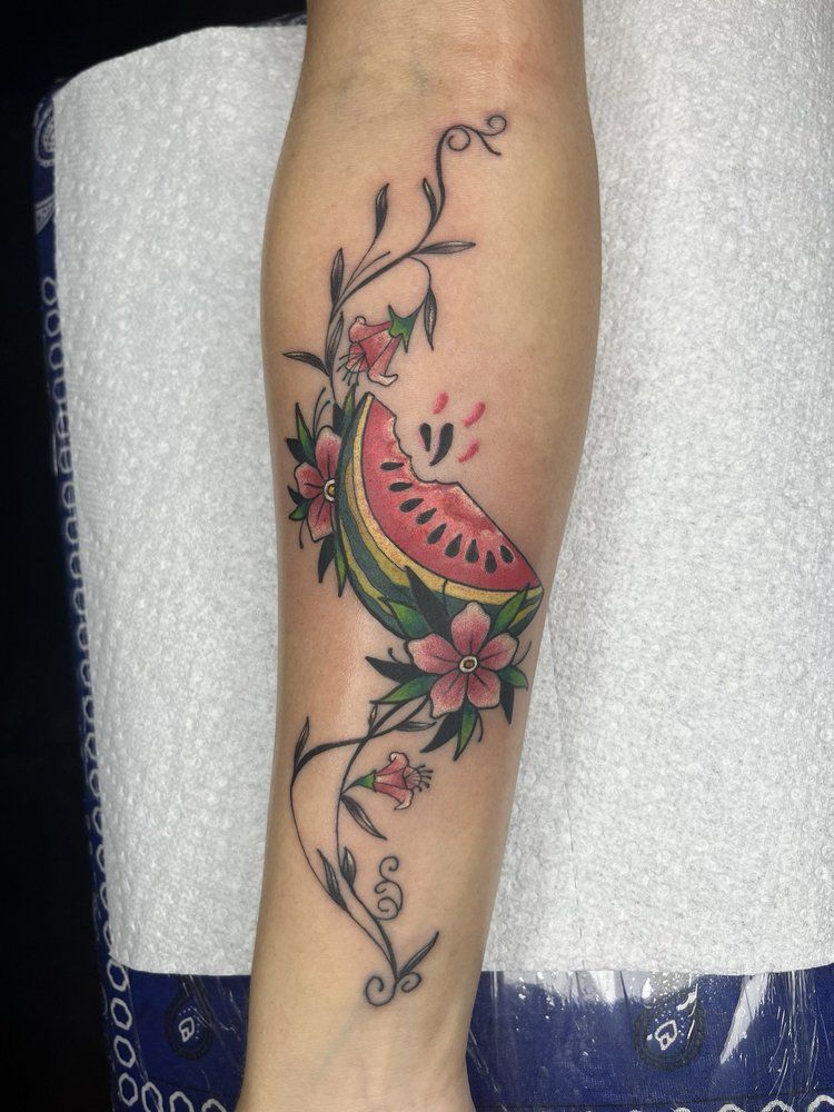 A woman has a watermelon tattoo on her forearm