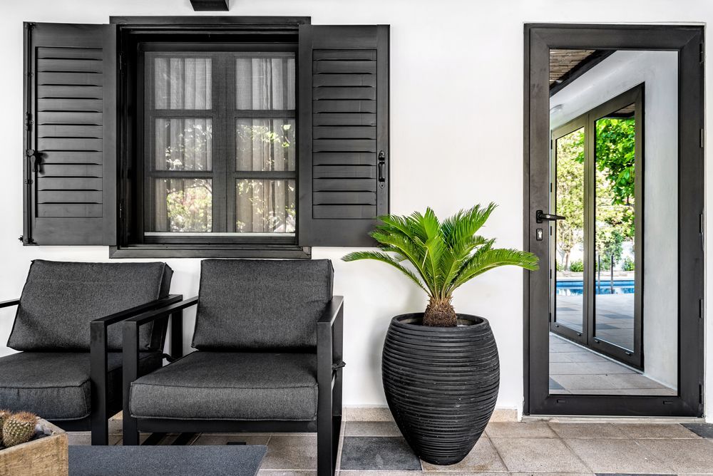 A Window And Shutter Behind Of Two Chair — Smith Aluminium In Soldiers Point, NSW