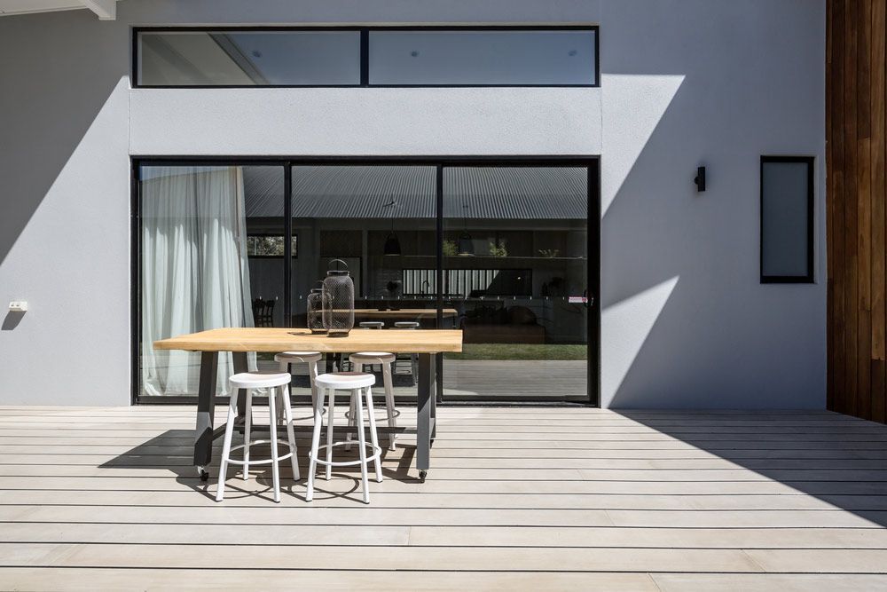 A Table And Stools On A Deck In Front Of A House — Smith Aluminium In Charlestown, NSW