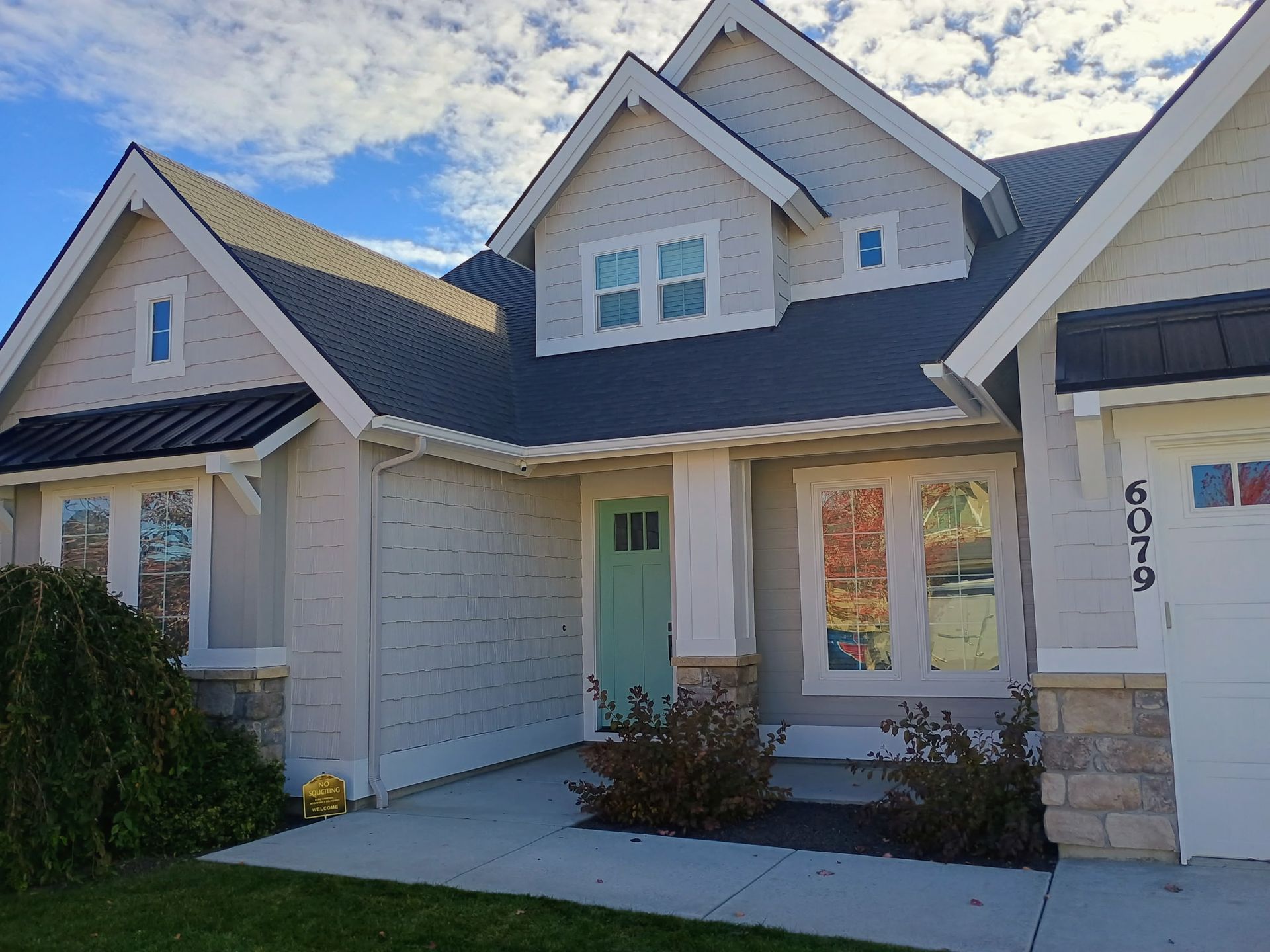 Exterior paint job of a house with a gray siding and a white brick wall