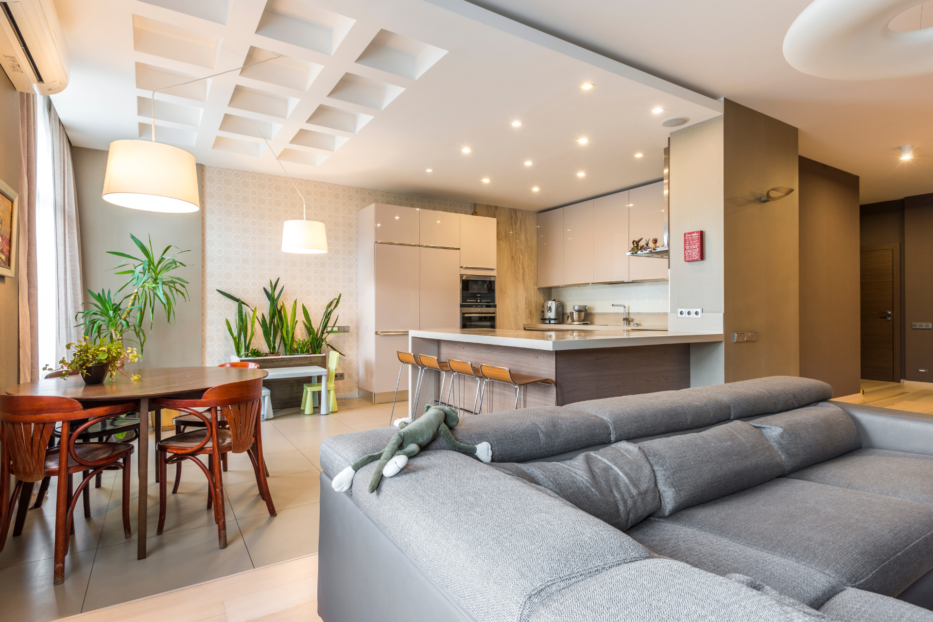 A living room with a couch , table , chairs and a kitchen.