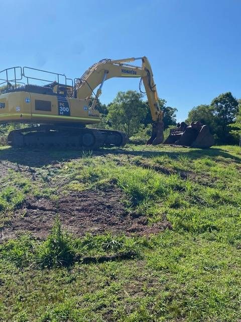 A Yellow Bulldozer Sits Idle on a Dirt Construction Site — GPE Plumbers In Kendall, NSW