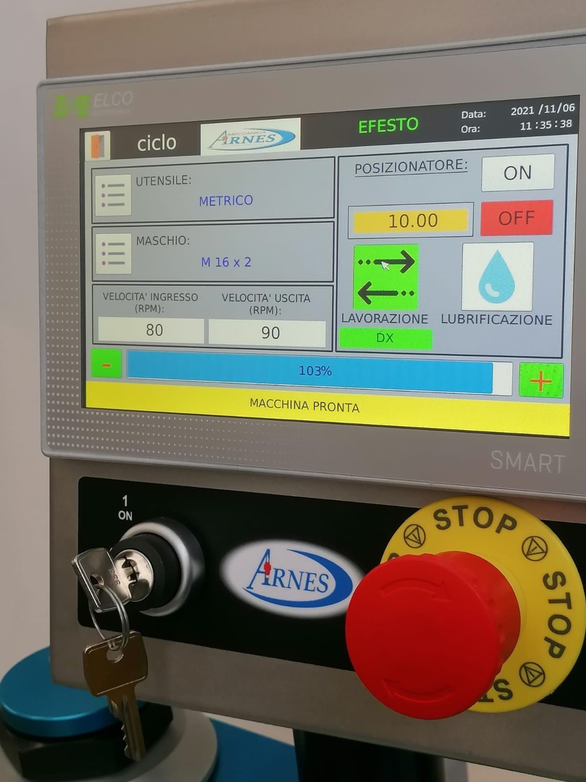 Pannello di controllo industriale con display touchscreen, pulsante di arresto di emergenza rosso e tasti sulla console della macchina.