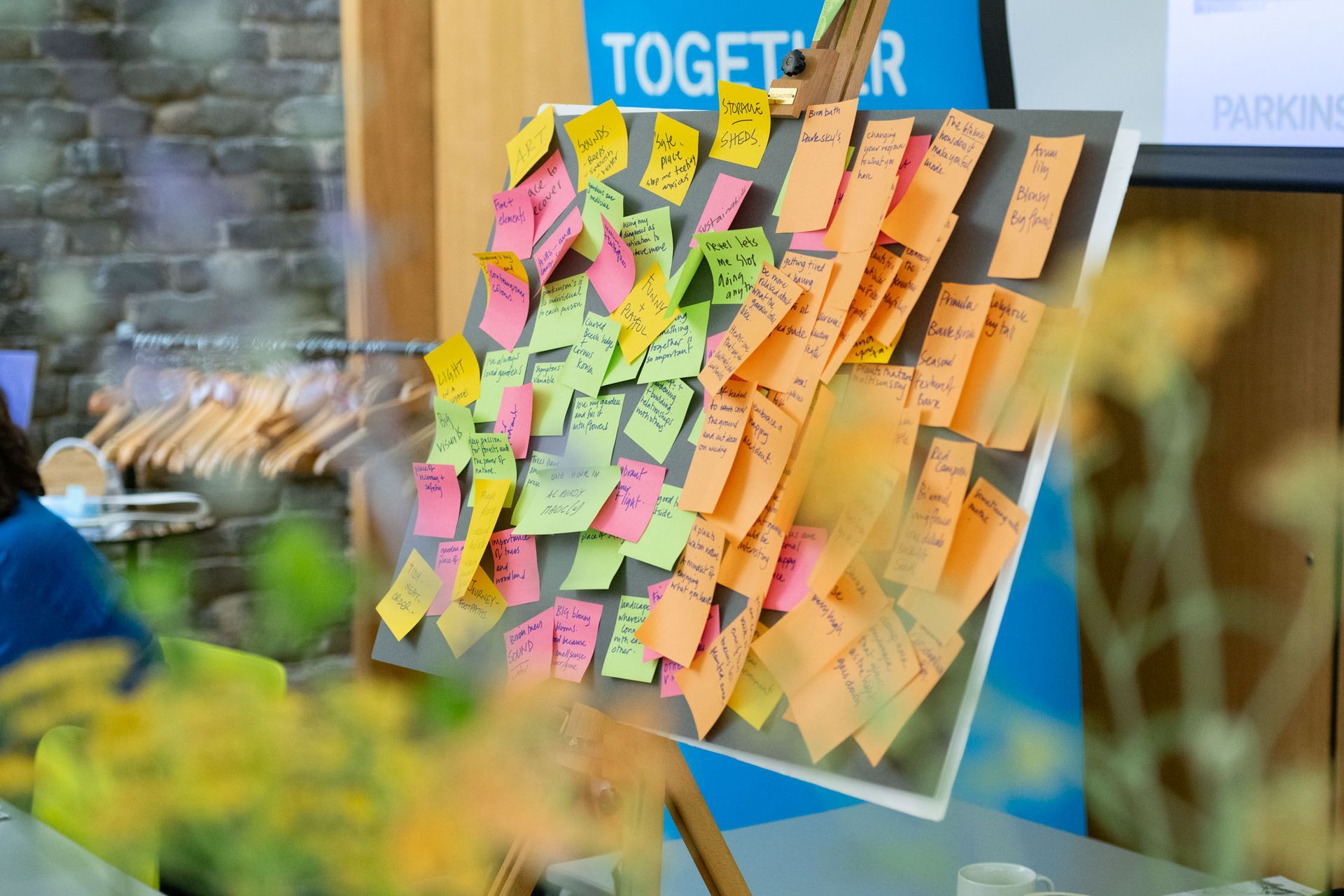 Colorful sticky notes arranged on a board labeled “TOGETHER” in a bright indoor window display.