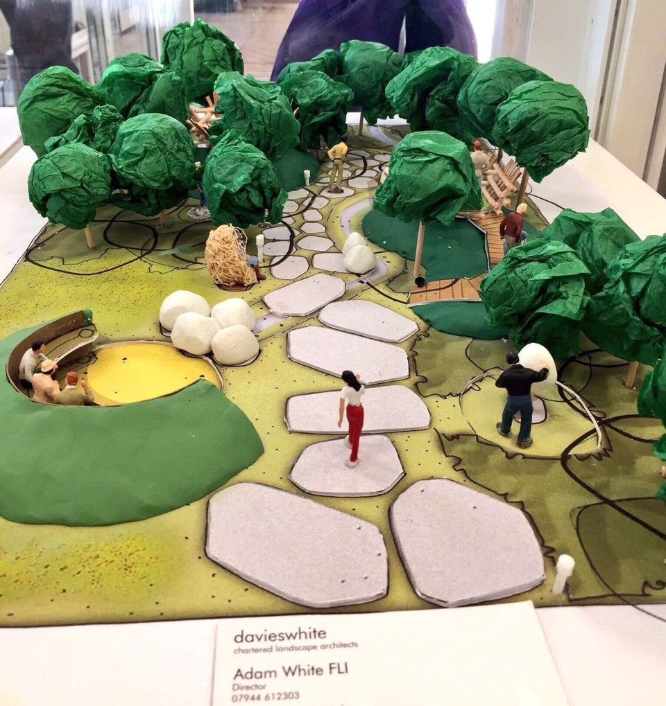 Model of a garden path with trees, figures, and a yellow circular feature, by Adam White.