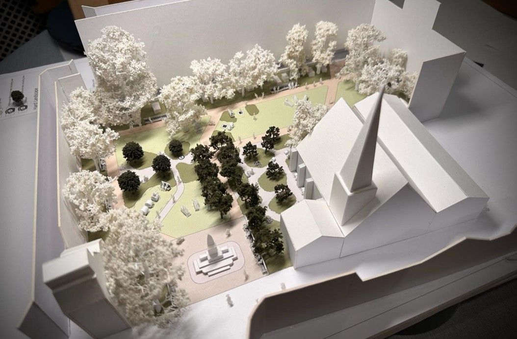 Architectural model of a church and surrounding park with trees.