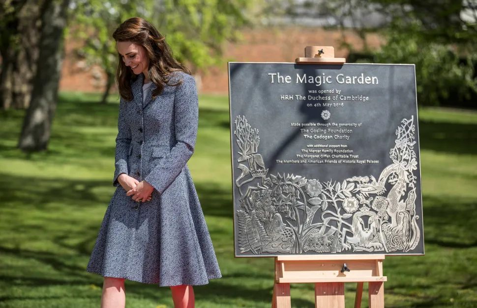Kate Middleton smiles next to a plaque for