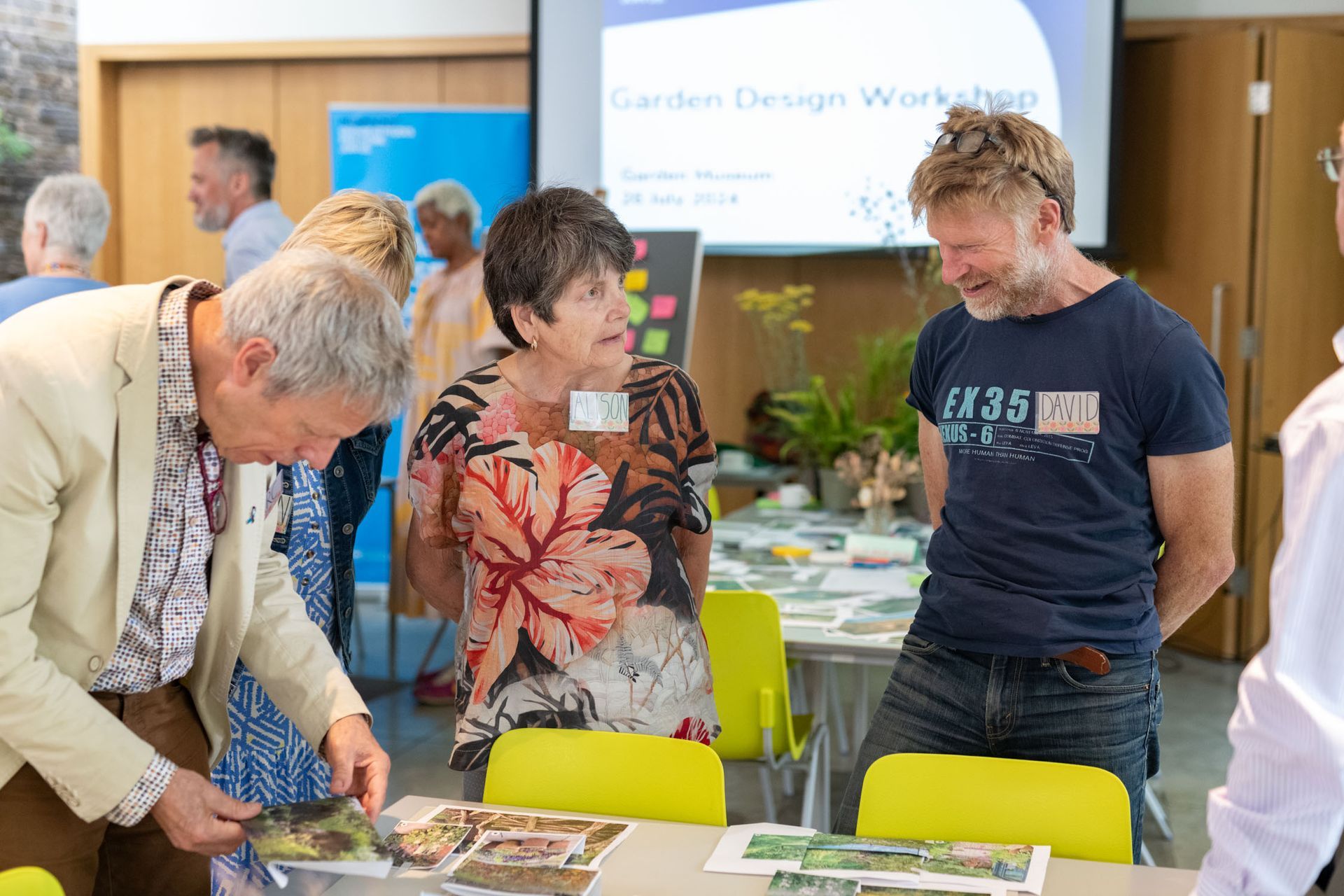 People gathered around a table at a garden design workshop, reviewing materials and plans.