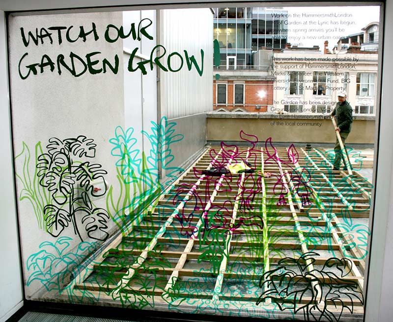 Window display showing a rooftop garden in progress; text