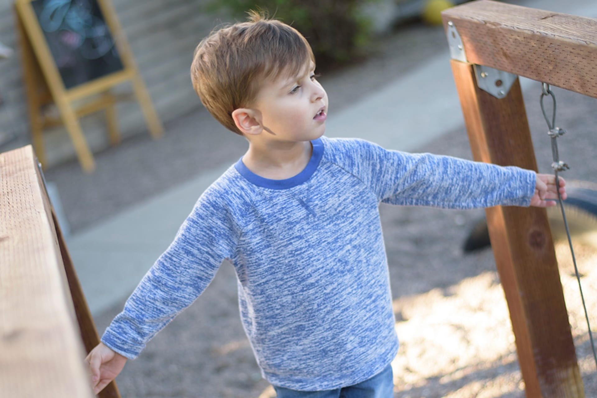 Child exploring outdoor Montessori environment with hands-on activity