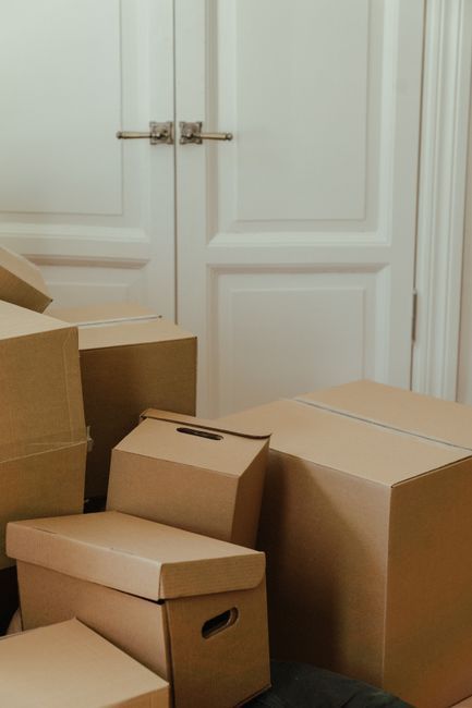 Stacked cardboard moving boxes in front of white double doors