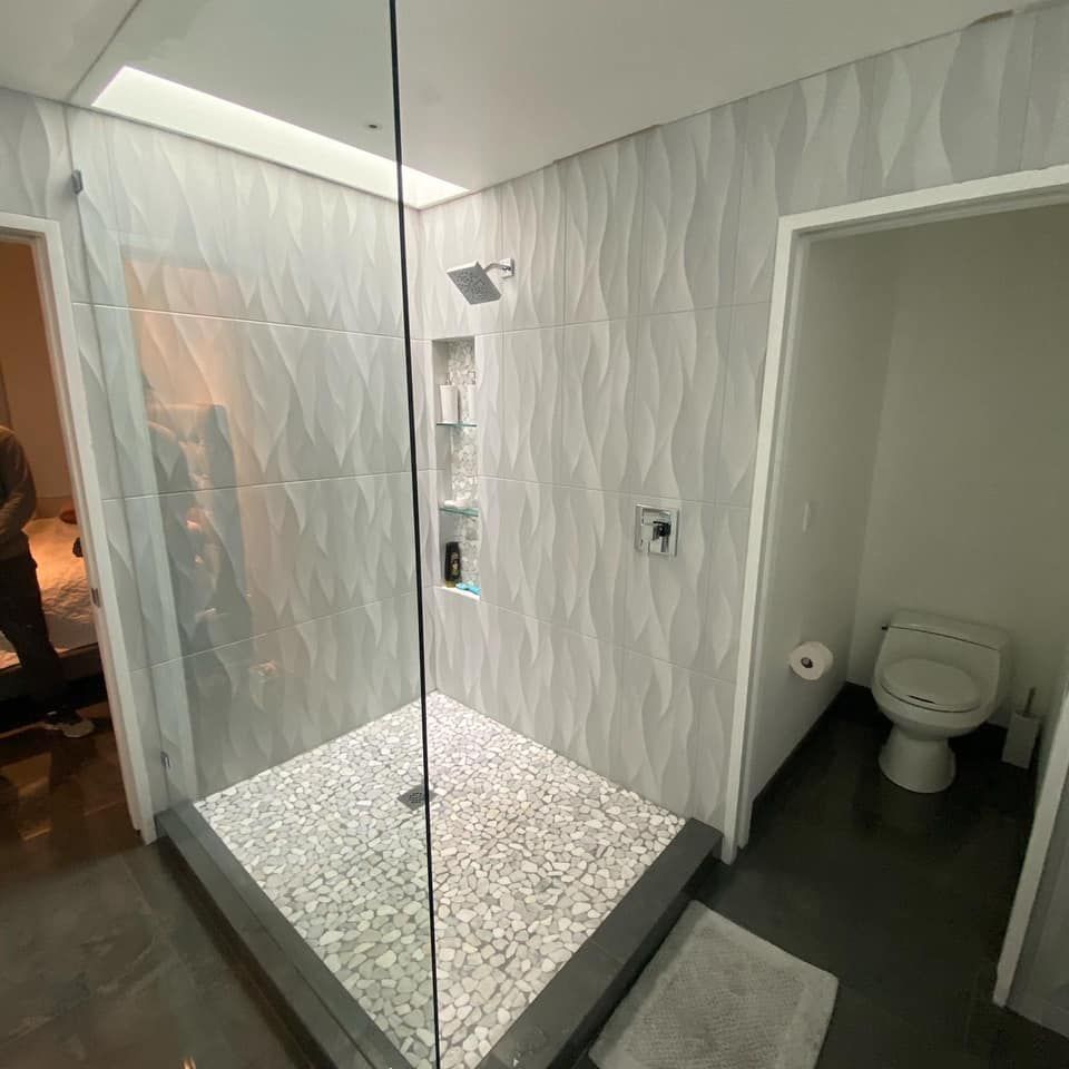 A shower niche in a bathroom with white tiles and a shelf.
