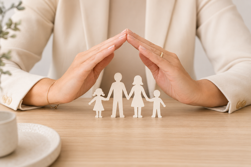Hands protecting a paper cut-out family, representing wills and estate planning at Airlie Legal