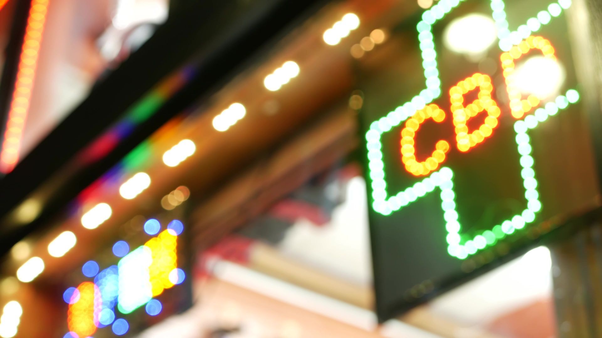 A glowing green LED cross sign with the letters