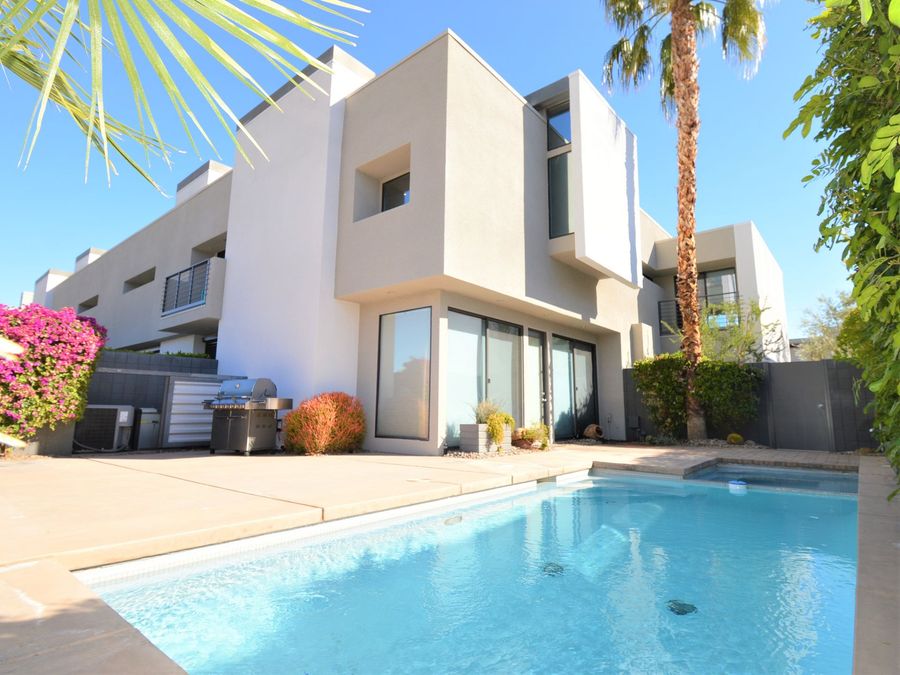 Prospective buyers touring a home exterior in the Coachella Valley with their agent