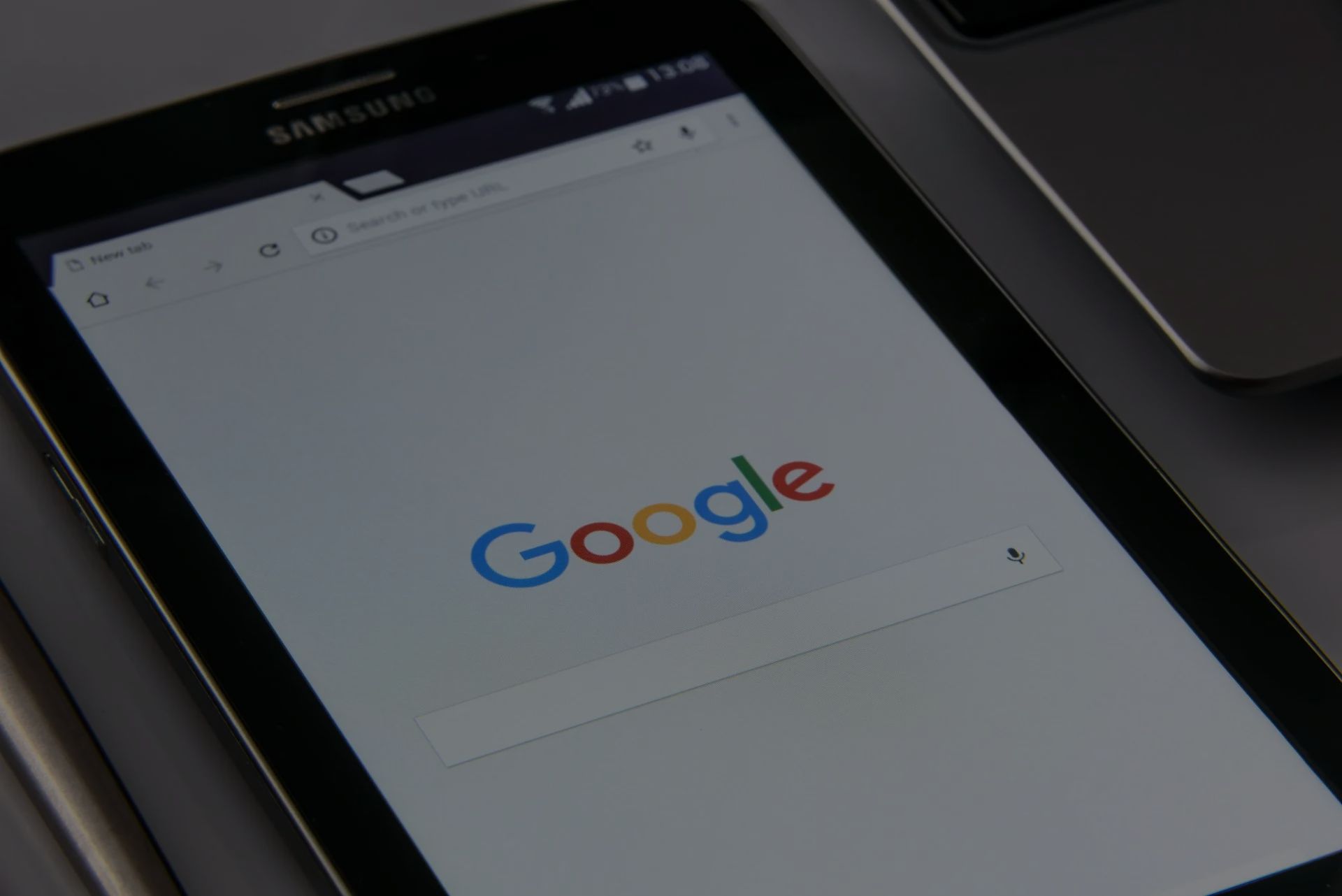 a close up of a cell phone displaying the google search page .